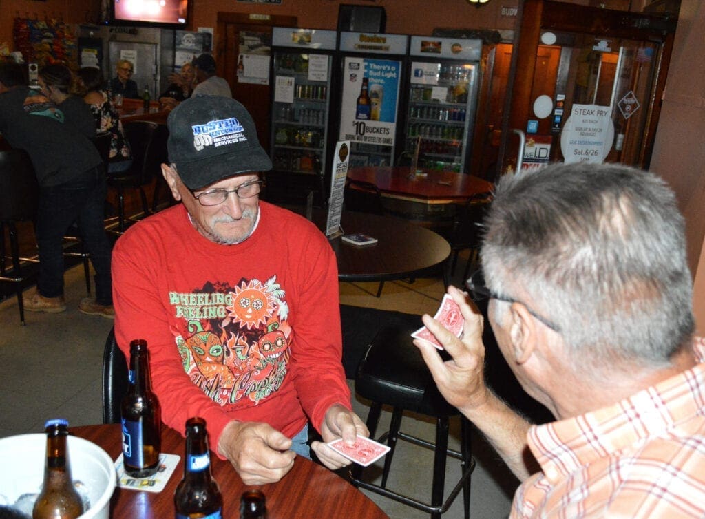 Two men doing card tricks.