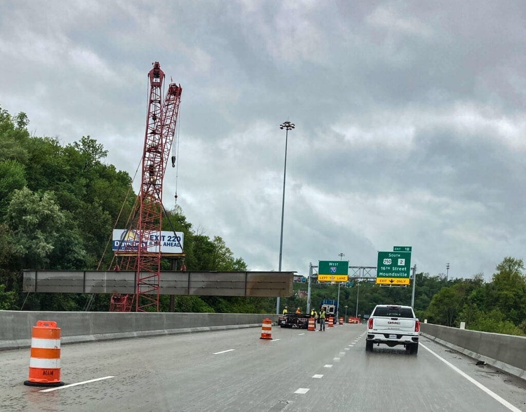 A red crane moving a girder.