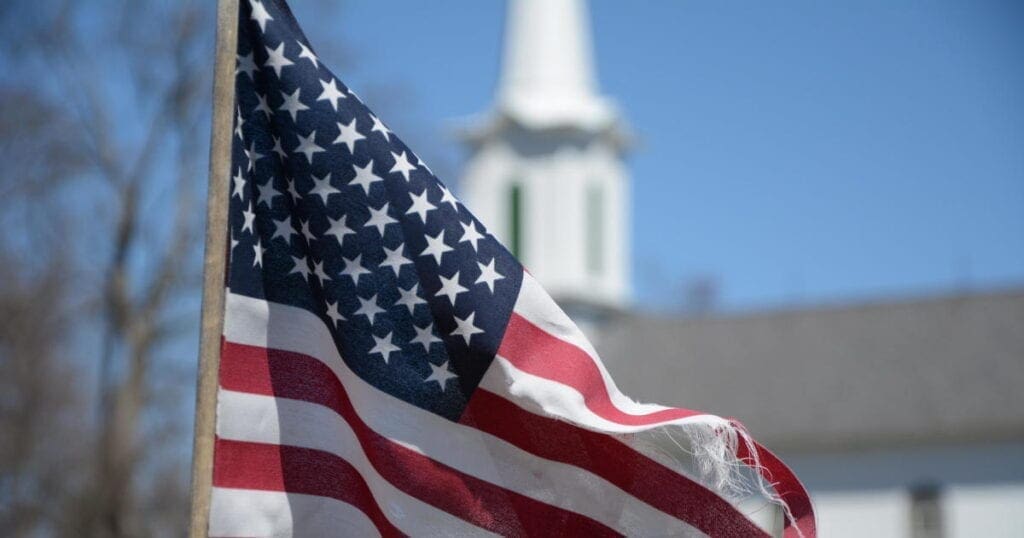 An American Flag in front of a Church.