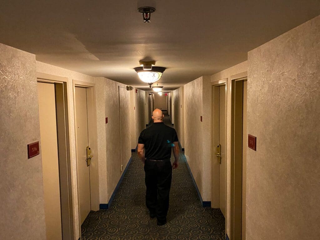 A man walking down a hotel hallway.