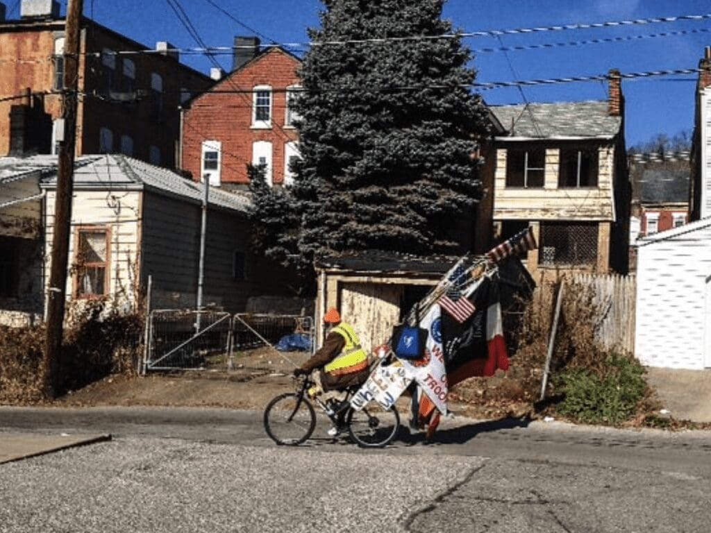 A man on a bike with flags.