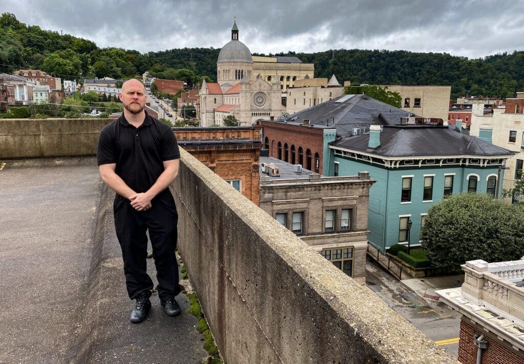 A man standing on the top of a parking garage.