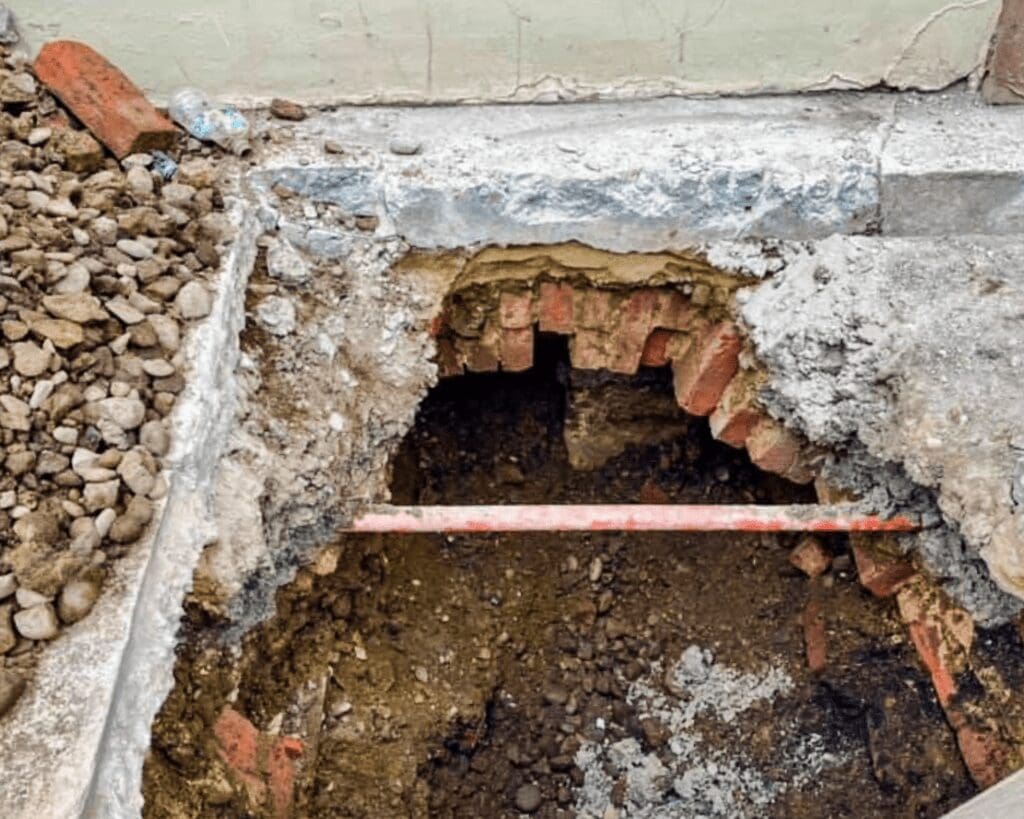 A bricked area under a sidewalk.