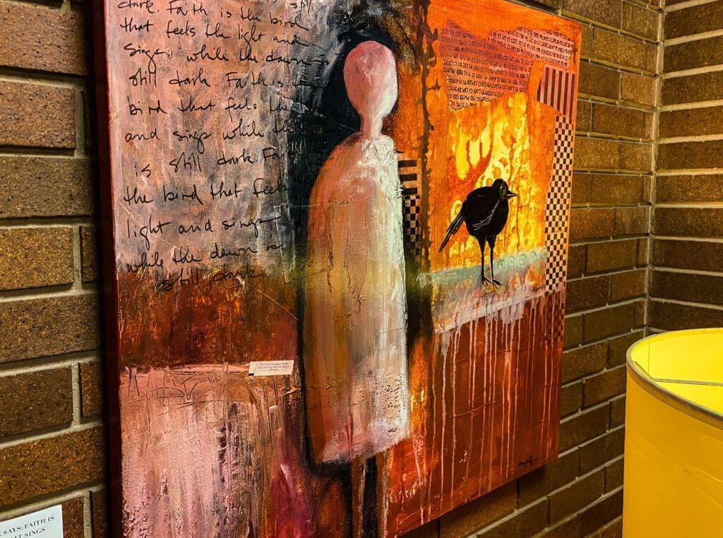 A painting hanging on brick.