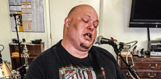 A photo of a guy playing a guitar.