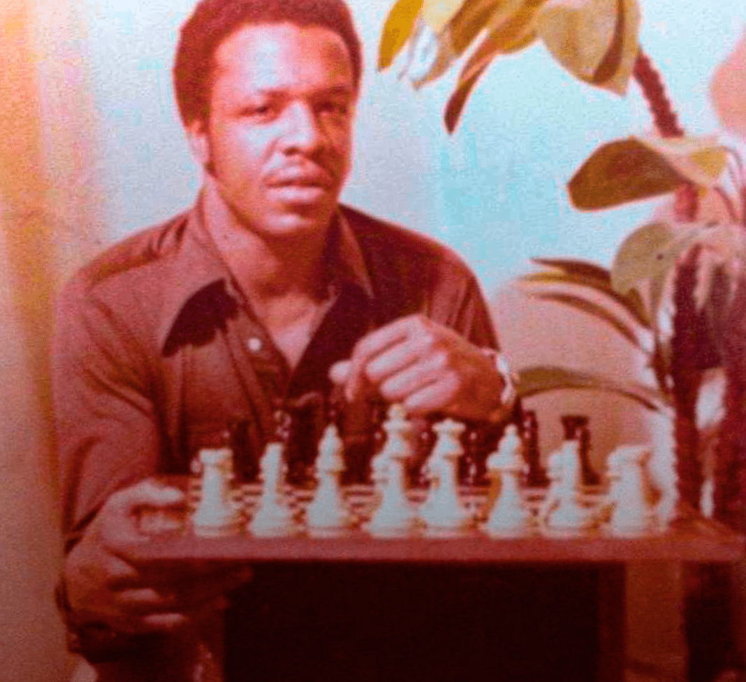 A black man playing chees.