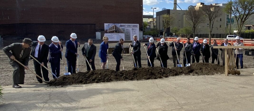 A large group of people with shovels./