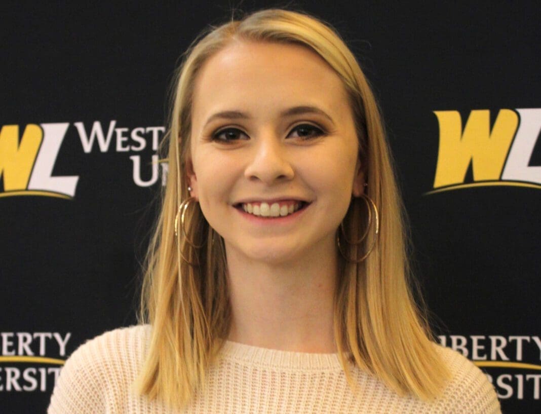 A blonde smiling for a photo.