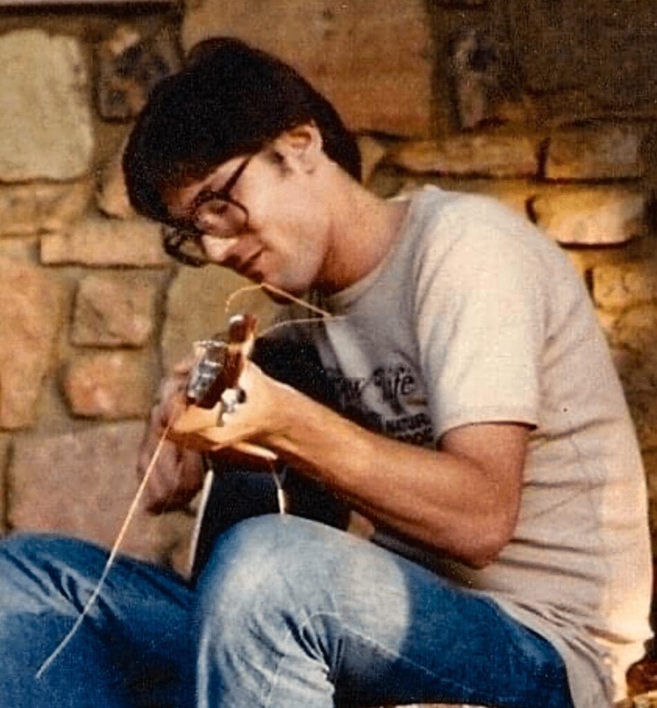 A man strumming on a guitar.