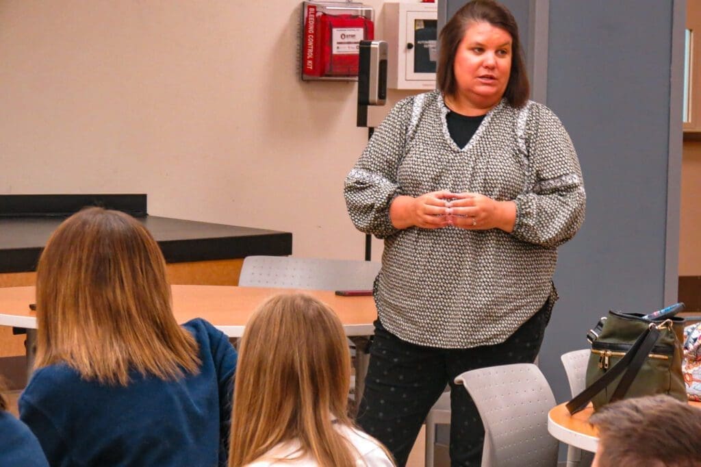 A woman in front of a class.