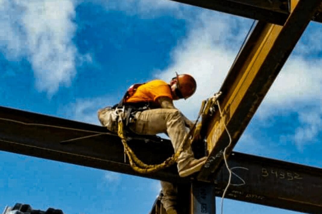 A man sitting on a girder.