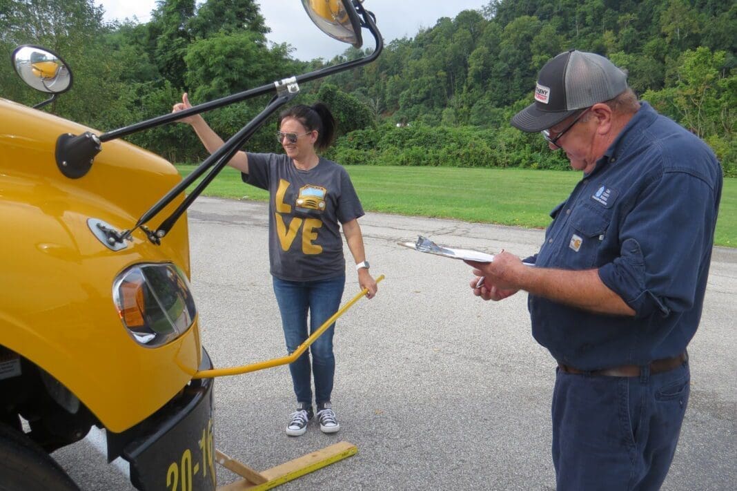 Two people near a school bus.