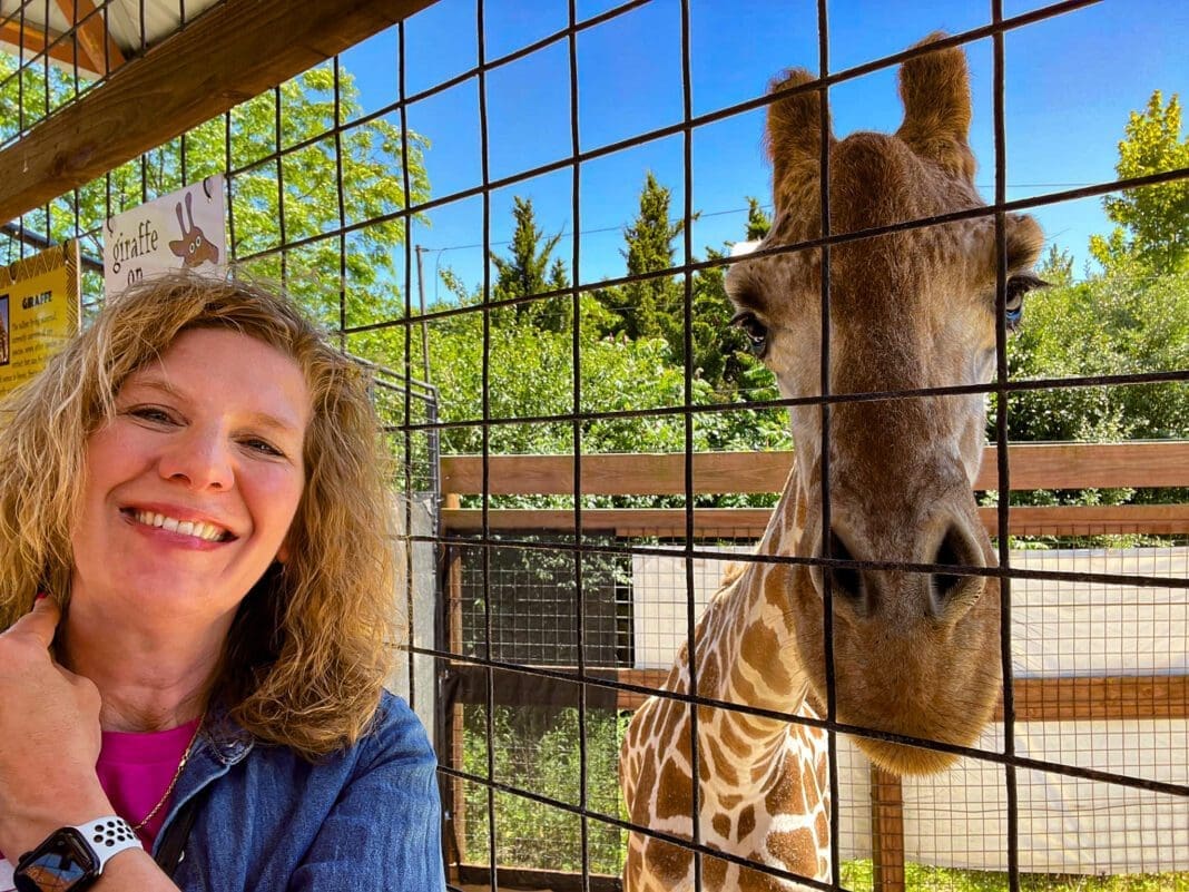 A woman and a giraffe.