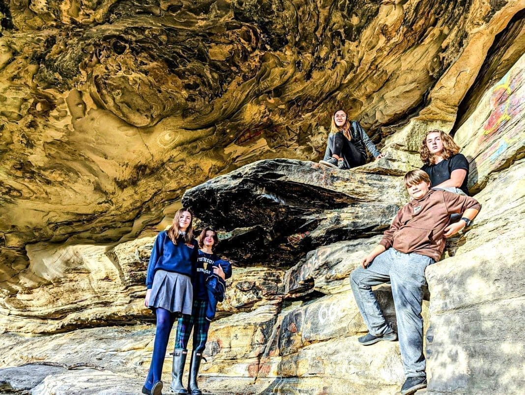 A few kids near a cave.