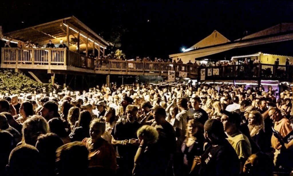 A large crowd at an outdoor music area.