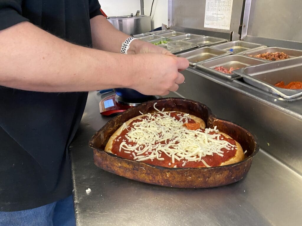 AS pizza being topped.