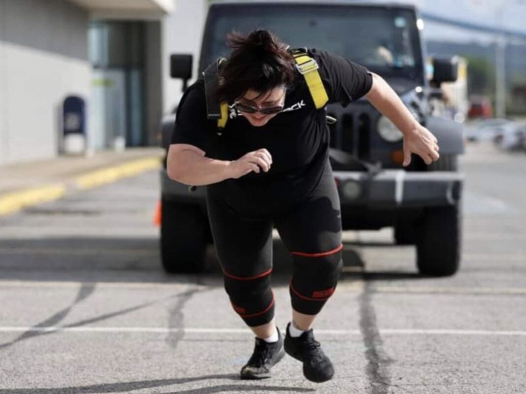 A woman pulling a Jeep.