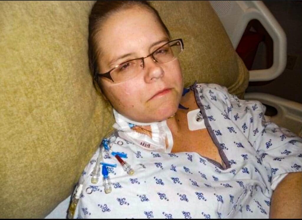 A woman in a hospital bed.