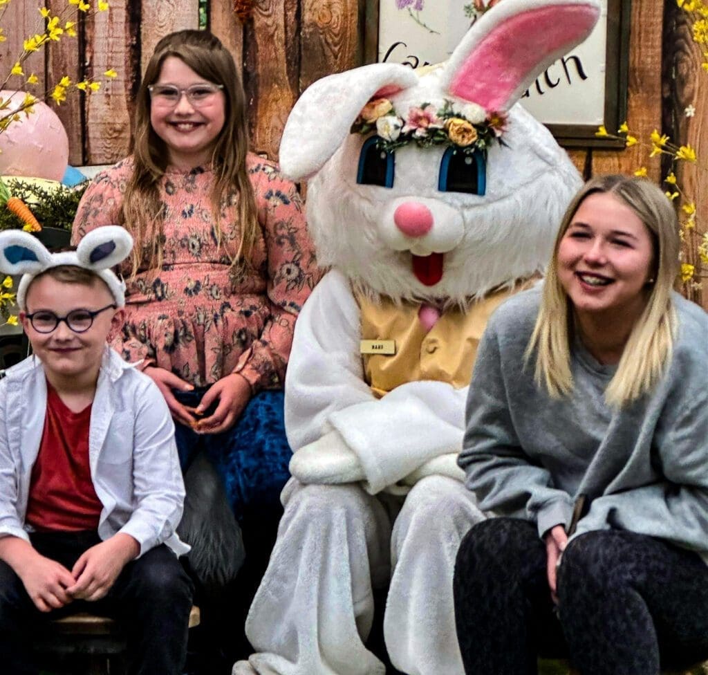 Three children with the bunny rabbit.