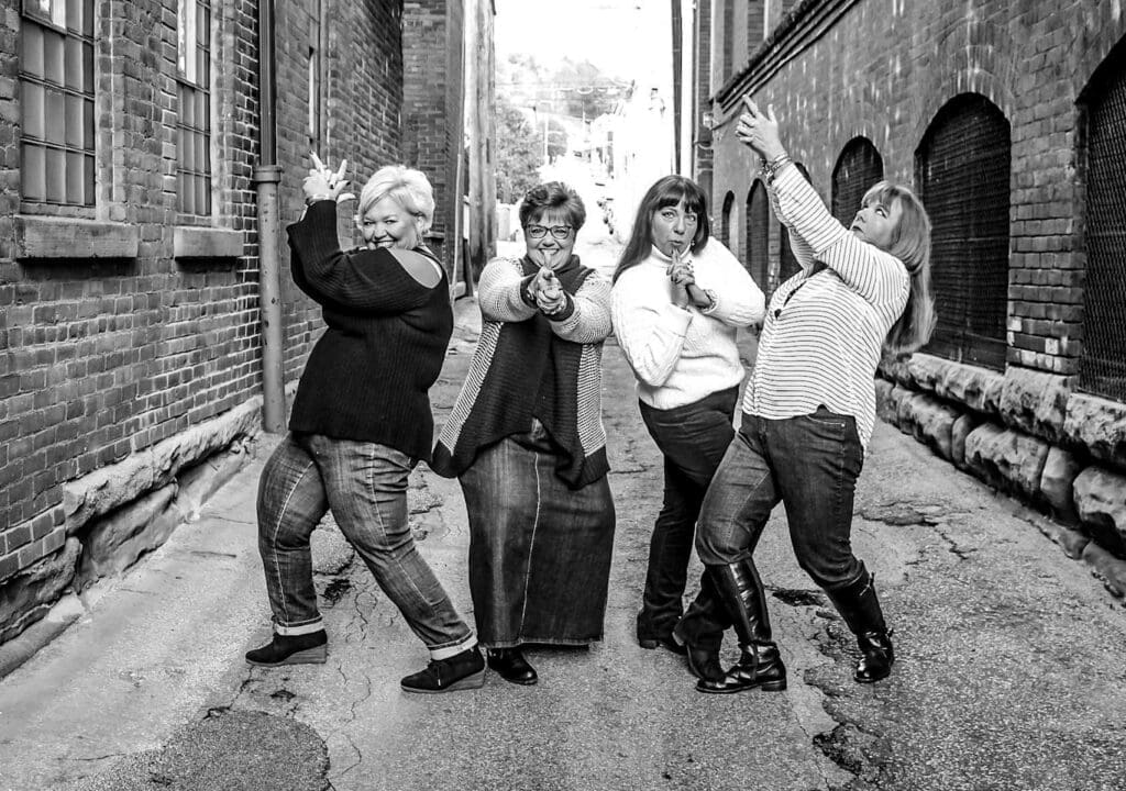 Four women in an alley.