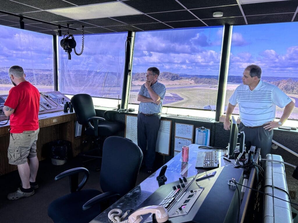 Three men in a airport tower.