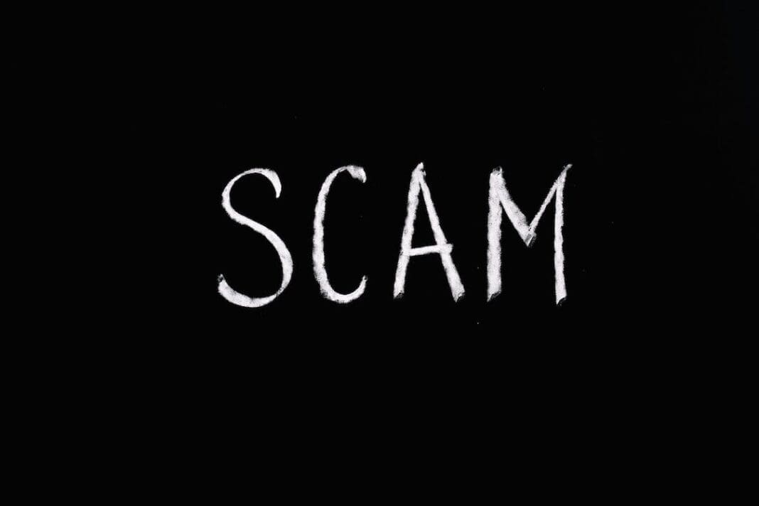 A placard that says scam.