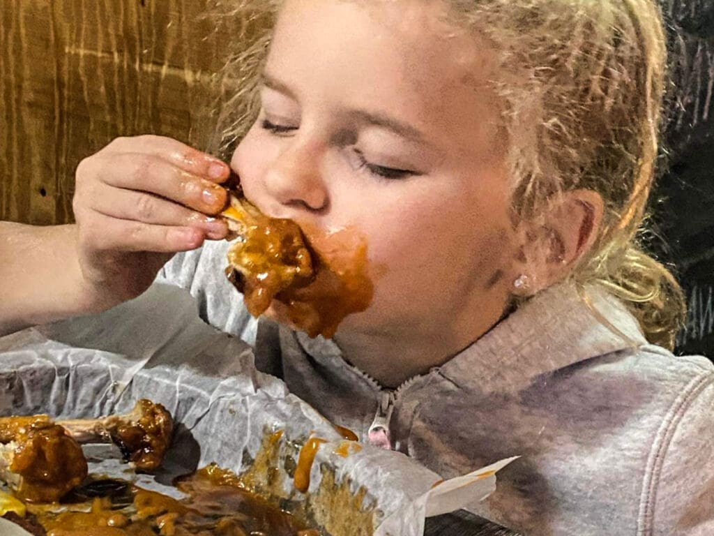 A child chomping down on a wing.