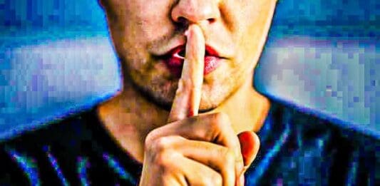 A man with his finger over his lips.