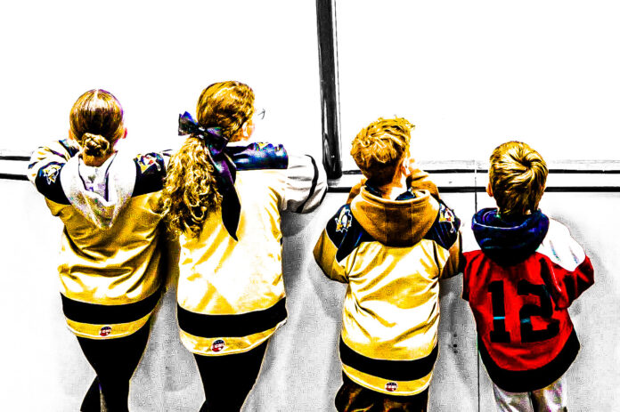 Kids watching hockey.