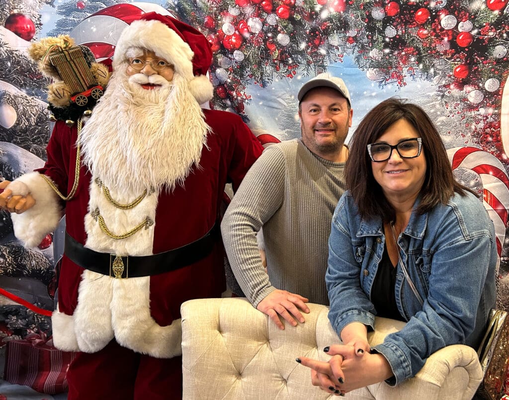 Two people next to Santa.