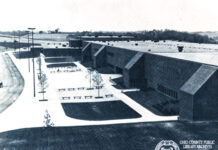 A black and white photo of a long building.