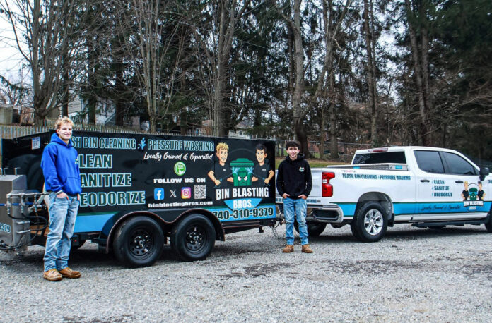 Two men near a trailer.
